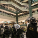 Riot police shield themselves as protesters throw objects at them as they chase protesters through a shopping mall on July 14, 2019 in Hong Kong.